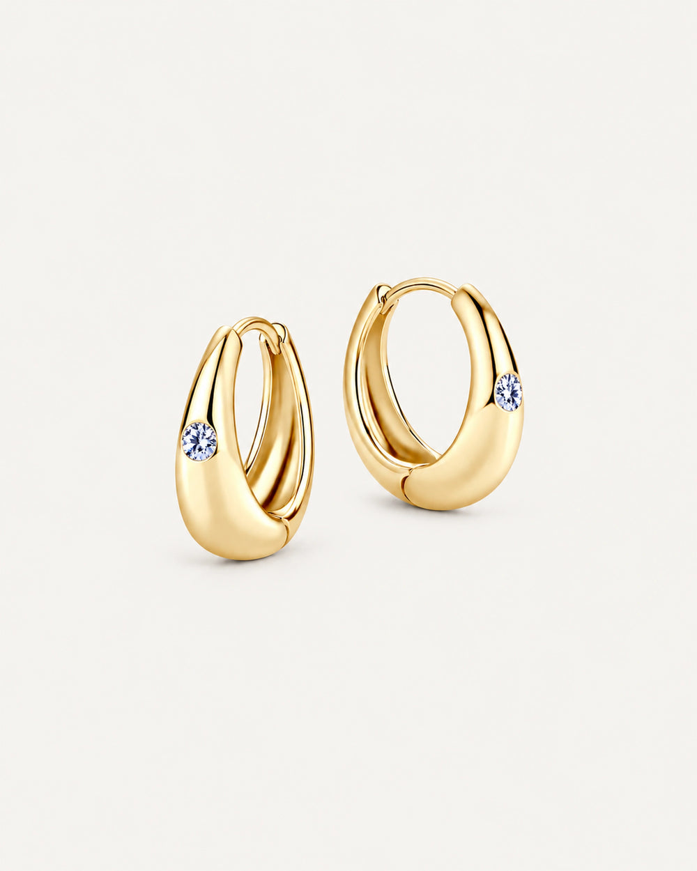 Pair of gold Audrey teardrop huggie earrings with one round moissanite accent on each front