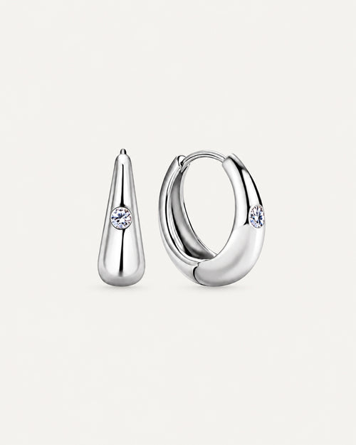 Pair of silver Audrey teardrop huggie earrings with one round moissanite accent on each front