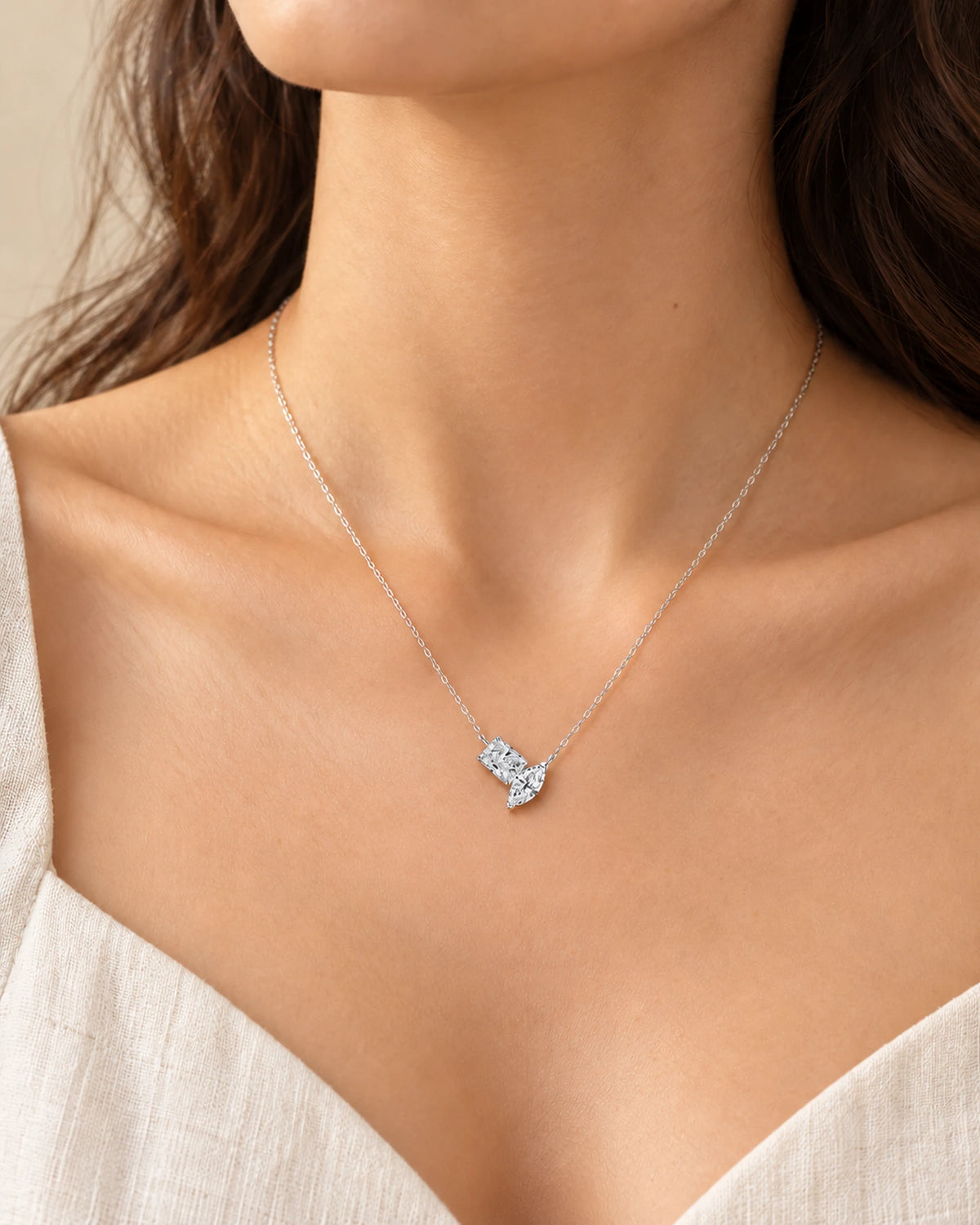 Silver-tone Elise two-stone necklace worn with a white top, with the pendant resting below the collarbones.