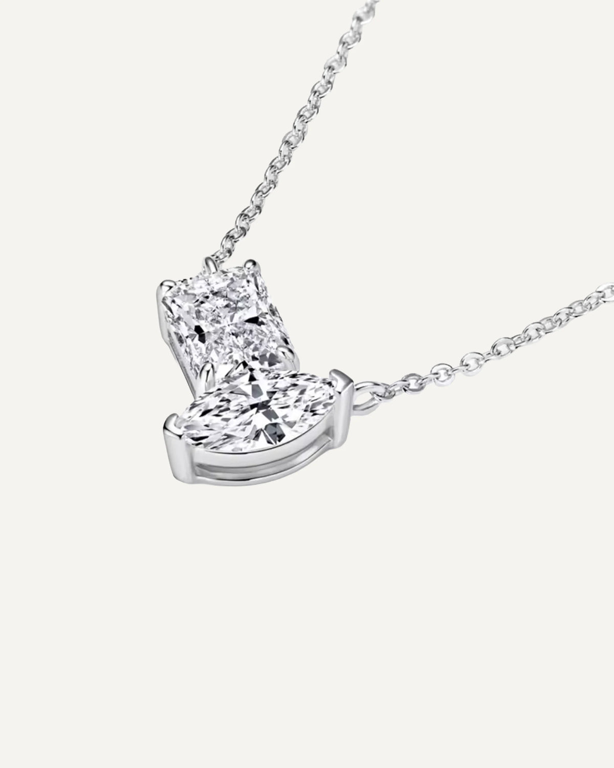 Angled close-up of Elise's silver-tone pendant showing the rectangular and marquise stones and their settings.