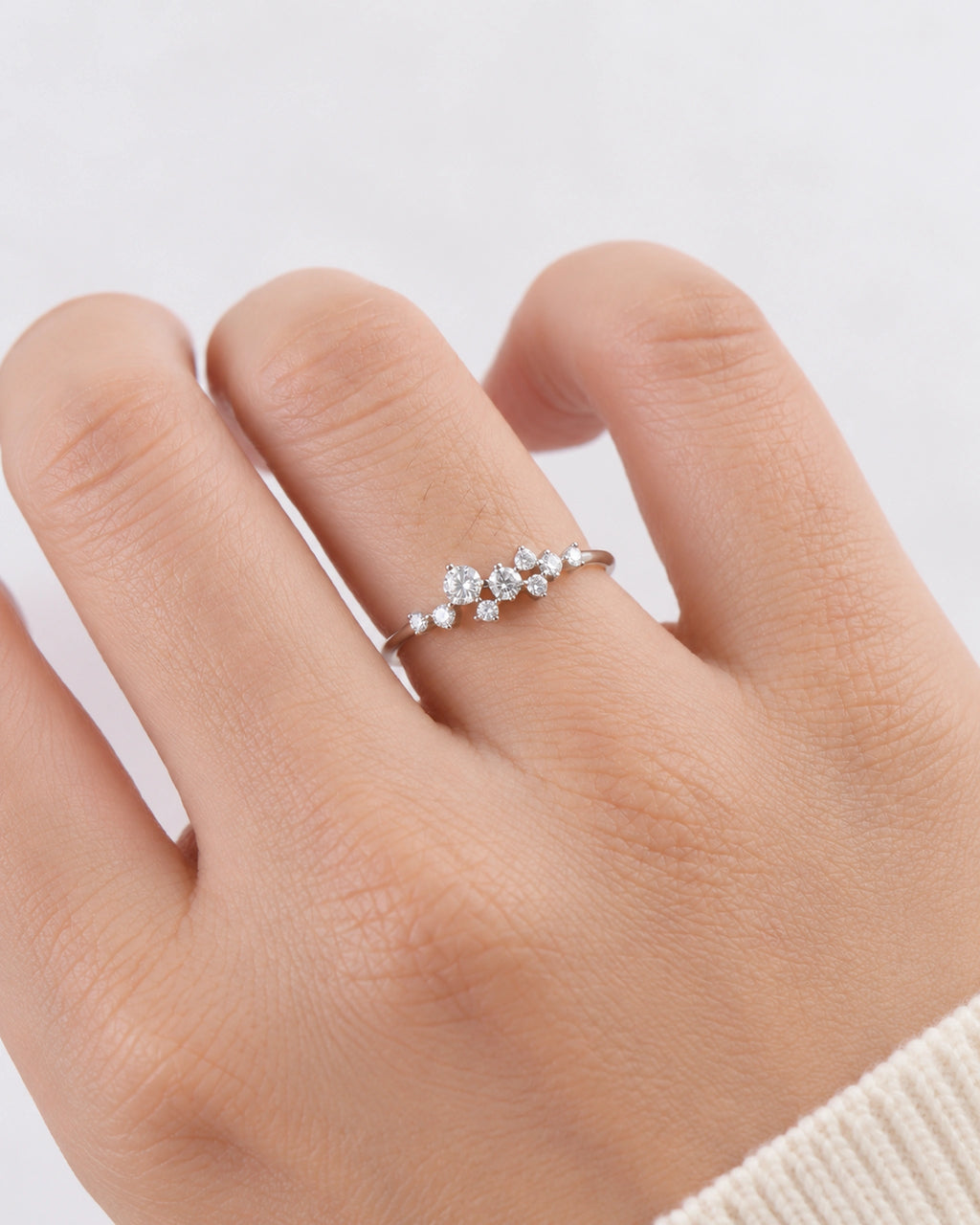 Silver Estelle scattered moissanite ring worn on an adult hand