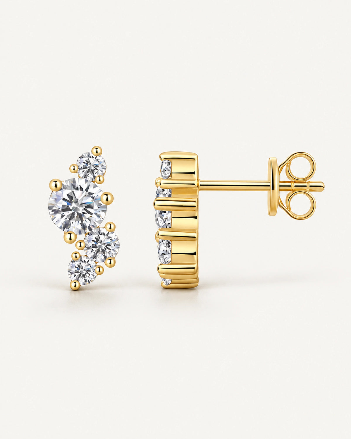 Juliette gold-tone stud earrings with four round moissanite stones in an asymmetric cluster, shown from the front and side with butterfly backs.