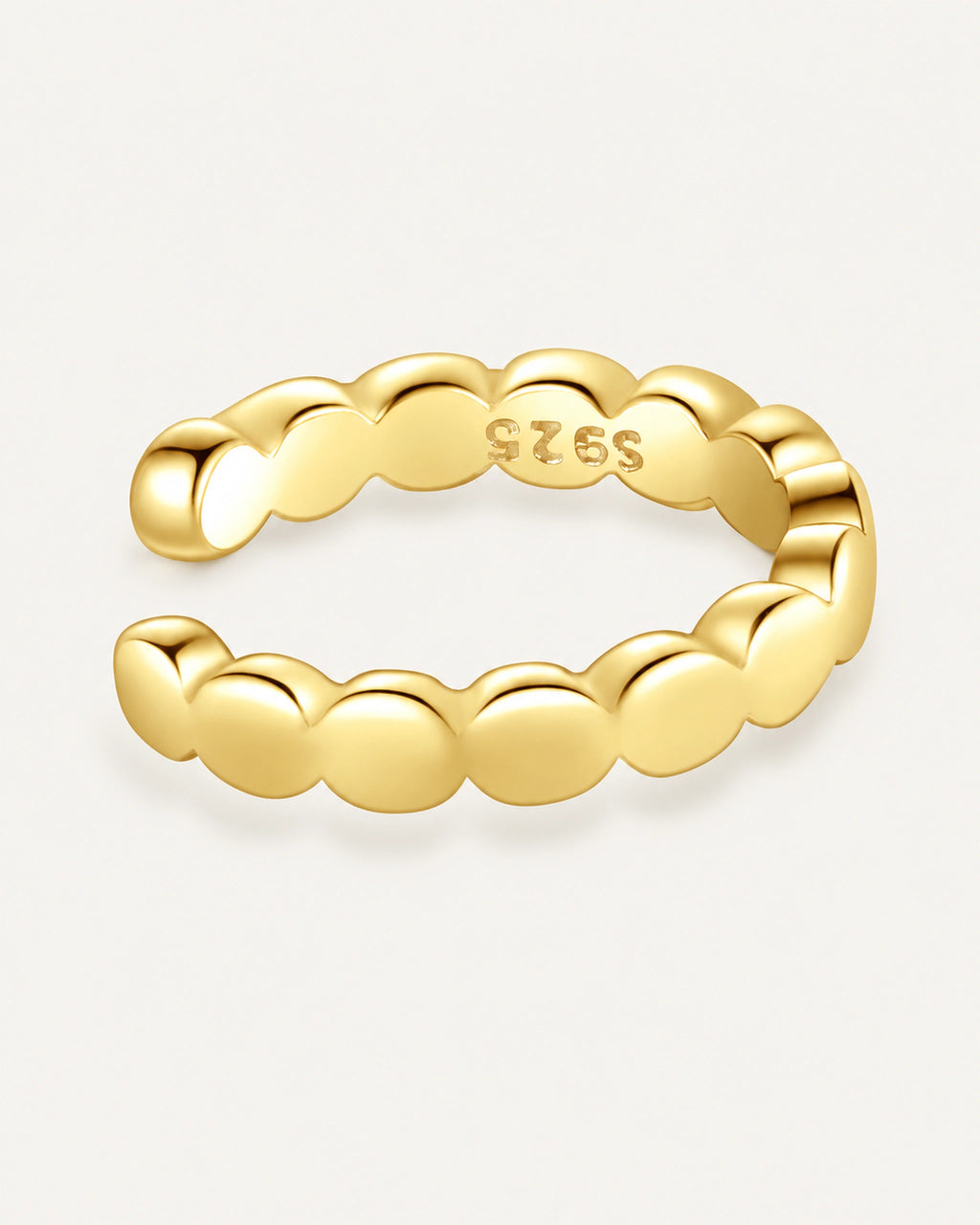 Single gold-plated Olivia ear cuff with round scallops, an open gap and an inner S925 stamp on a warm off-white background.